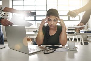 stressed out businesswoman surrounded by colleagues needing help overworked no support wellbeing mental health wellness