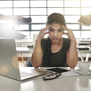 stressed out businesswoman surrounded by colleagues needing help overworked no support wellbeing mental health wellness