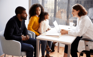 healthcare family sitting in doctors office to manage wellness and physical health