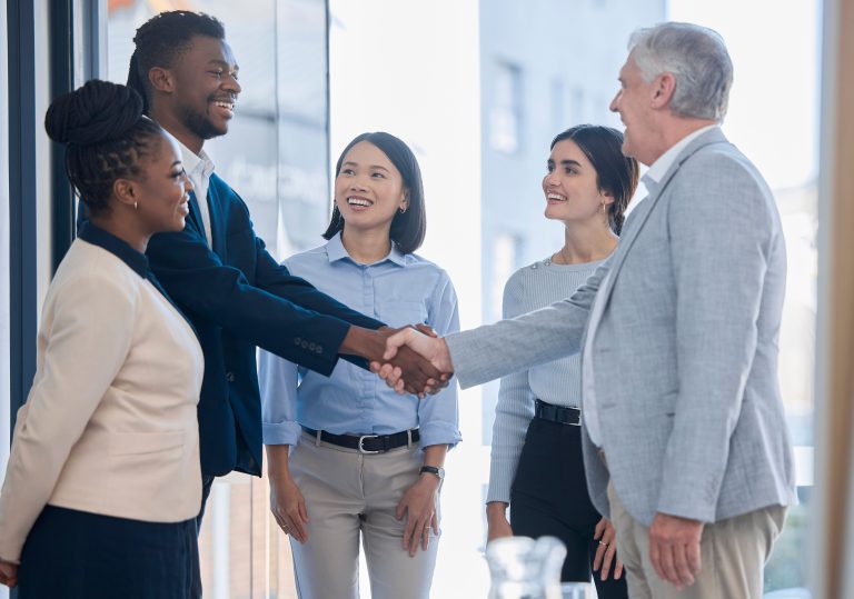 Meeting between different teams and different employees and employers. Different races all working together in a diverse workplace and are happy with a great work culture. Trust handshake