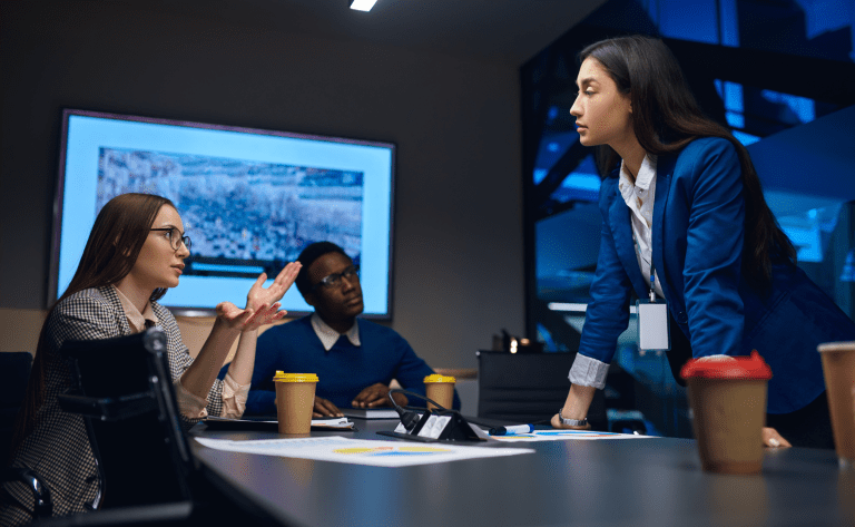 A diverse of male and female employees talking together to work out how to proceed with a complicated matter they are dealing with in the workplace.