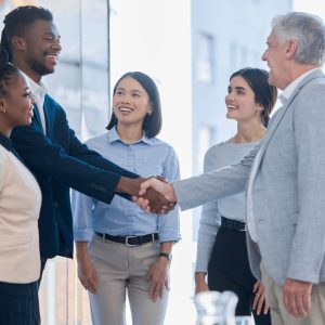 Meeting between different teams and different employees and employers. Different races all working together in a diverse workplace and are happy with a great work culture. Trust handshake