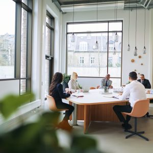 workplace employees employer engagement meeting team strategy planning leaders communication Smiling group of diverse businesspeople sitting around a boardroom table in an office during a meeting