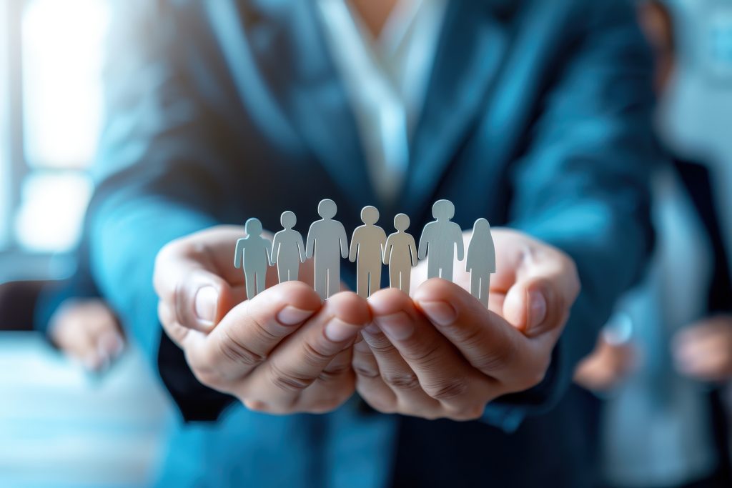 Protecting Our People: A symbolic image of a business leader holding a chain of paper cutouts representing a diverse team. This image evokes a sense of responsibility, care, and the importance of valu