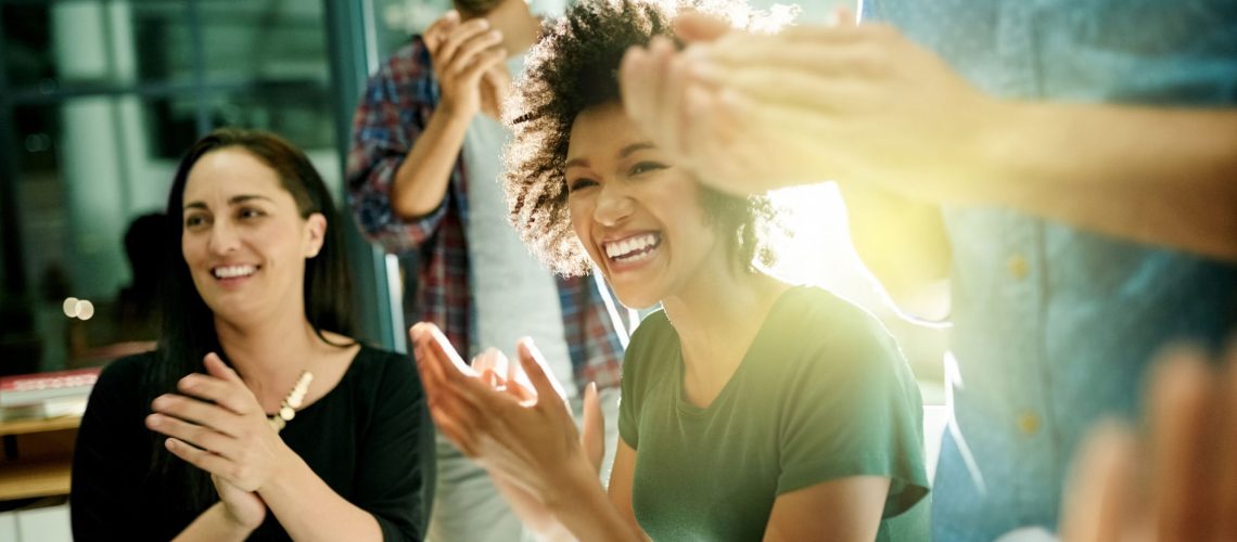 Shot of a team of creative businesspeople applauding an achievement  while working late in the boardroom