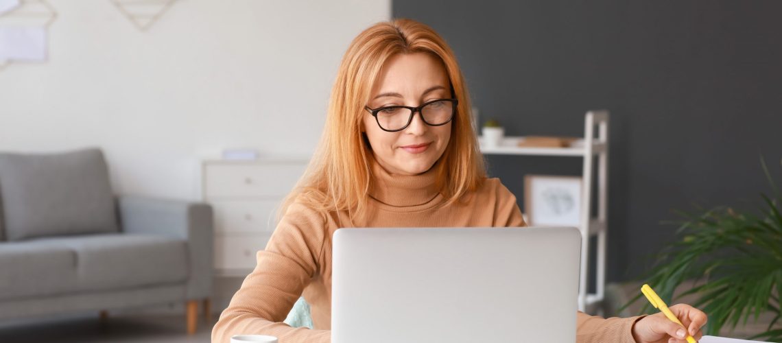 Mature woman using laptop for online learning at home