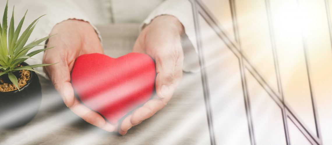 Red heart in hands of doctor; health insurance concept; multiple exposure wellness wellbeing mental health care