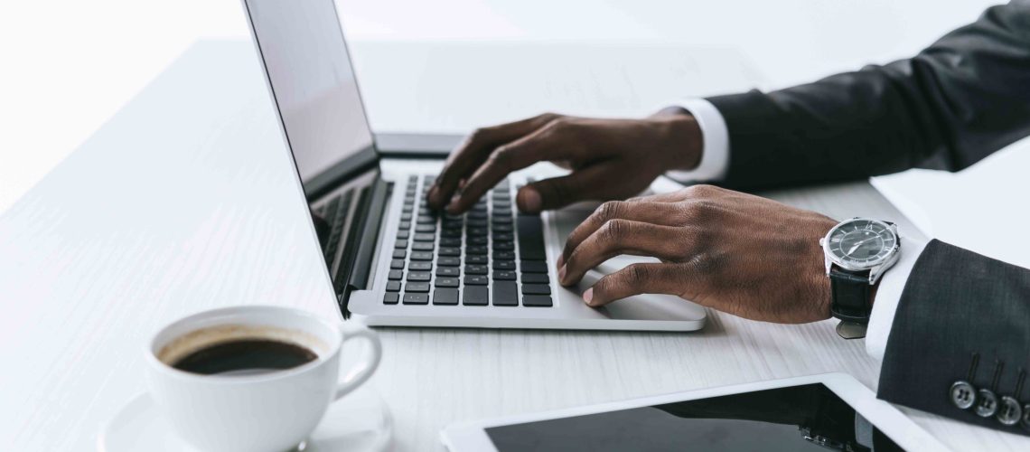 Business_man_using_laptop_with_coffee_and_papers