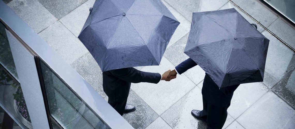 Businessman_shaking_hands_in_rain