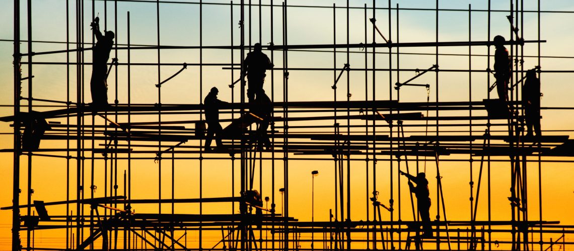 Construction site, silhouettes of workers against the light/