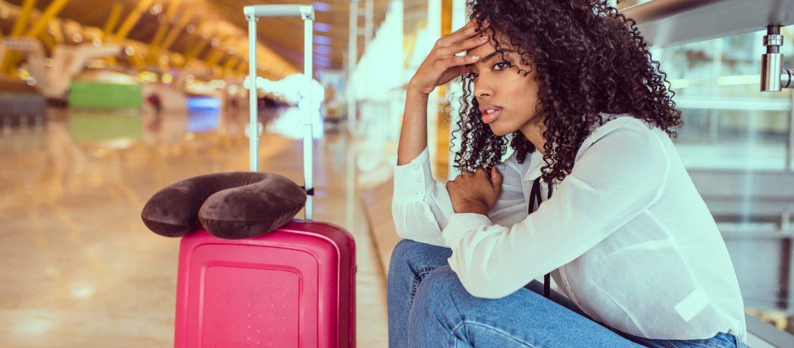 Woman sad and unhappy at the airport with flight canceled