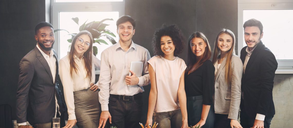 Successful managers posing and looking at camera, having break in office