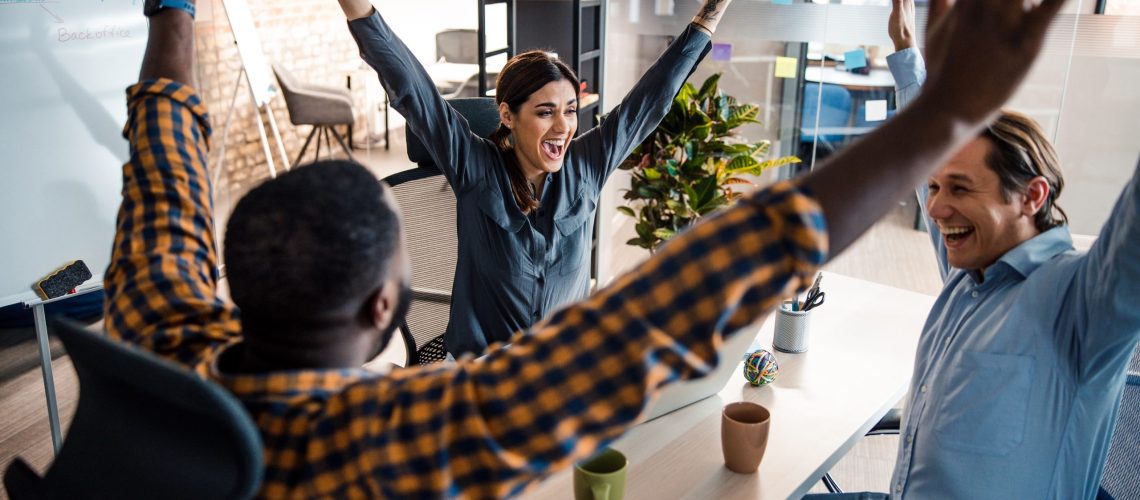 Happy together. Attractive brunette woman keeping smile on her face while looking at her colleagues