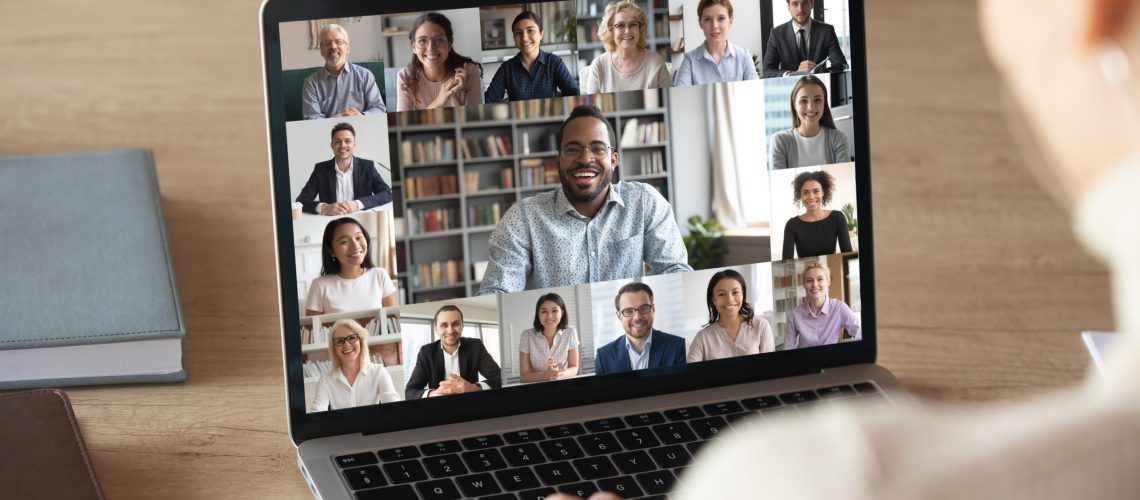 Back view of female employee speak talk on video call with diverse colleagues on online briefing, woman worker have Webcam group conference with coworkers on modern laptop at home virtual meeting remote working