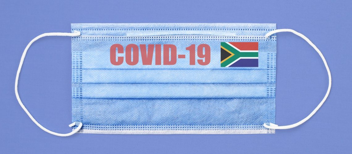 Medical mask and text or inscription Covid-19. Coronavirus pandemic concept. Flag of South Africa.