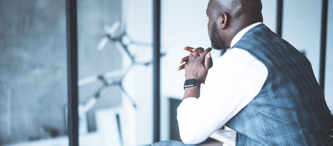 Businessman Sitting Back to the Camera in his Modern Spacious Apartment. Time to Make Big Decisions. Close-up. Copy space. High quality photo