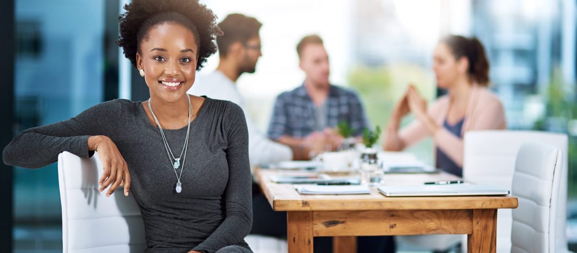 Portrait of a confident young businesswoman having a meeting with her colleagues.