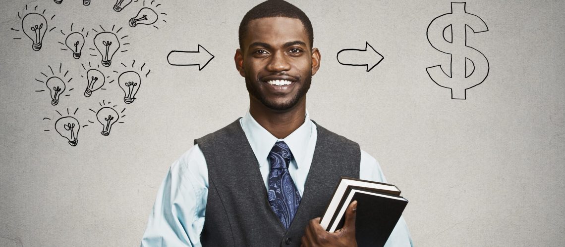 Happy, smiling handsome man holding books has ideas ready for financial success isolated black grey wall background. Positive human facial expression dynamism. Education economics concept