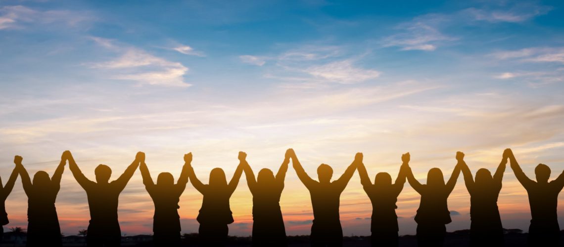 Silhouette of group happy business team making high hands over head in beautiful sunset sky evening time for business success and teamwork concept in company