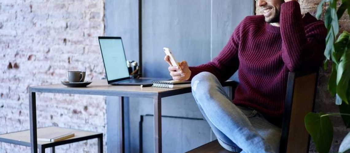 Happy businessman smiling at phone