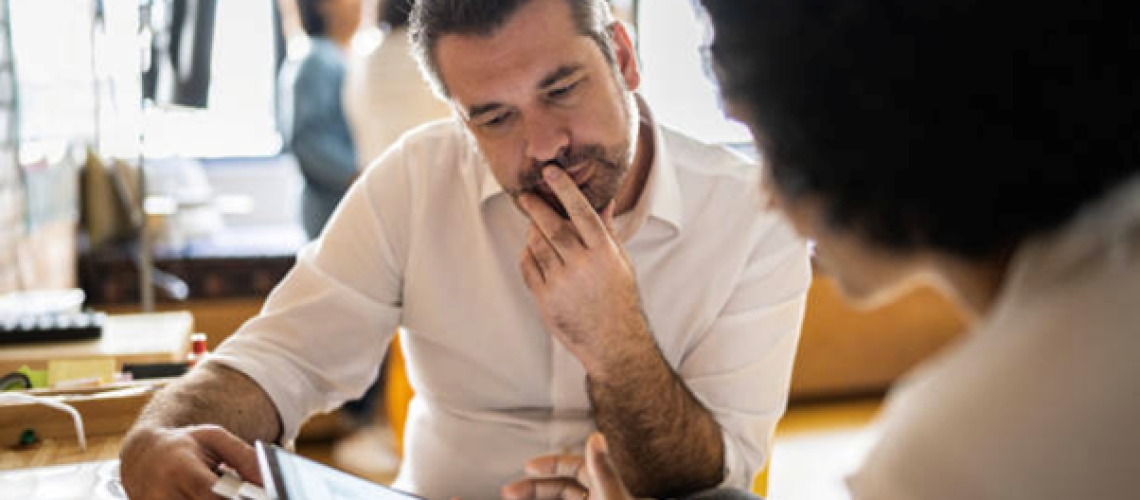 Employees talking to each other about a project so that they can create solutions to problems identified