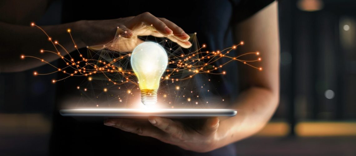 Abstract. Innovation. Hands holding tablet with light bulb future technologies and network connection on virtual interface background, innovative technology in science and communication concept