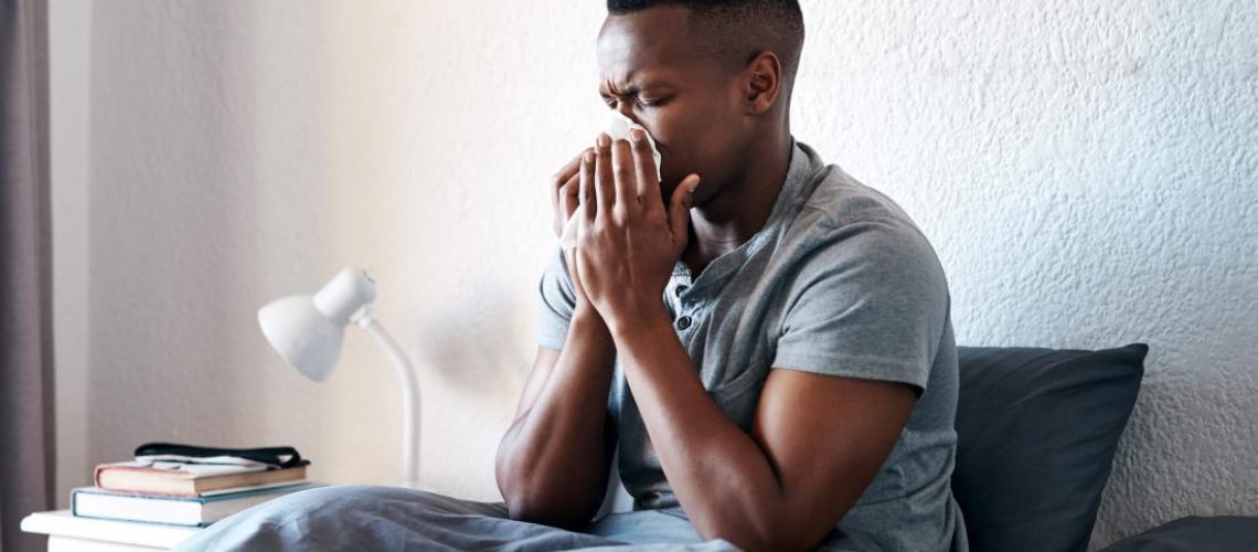 a-man-blowing-his-nose-in-bed-because-he-has-either-influenza