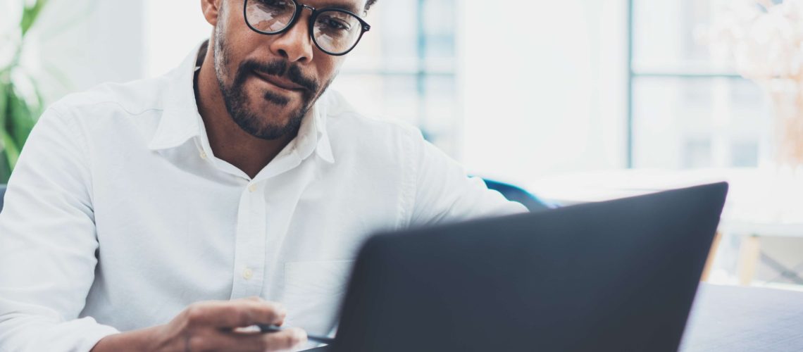 business man working concentrating holding pen on laptop high res