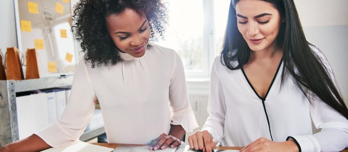 business_women_talking_to_each_other_and_working