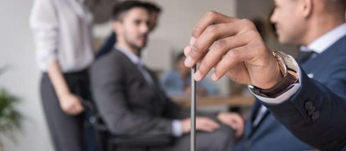 businessman holding pencil in meeting