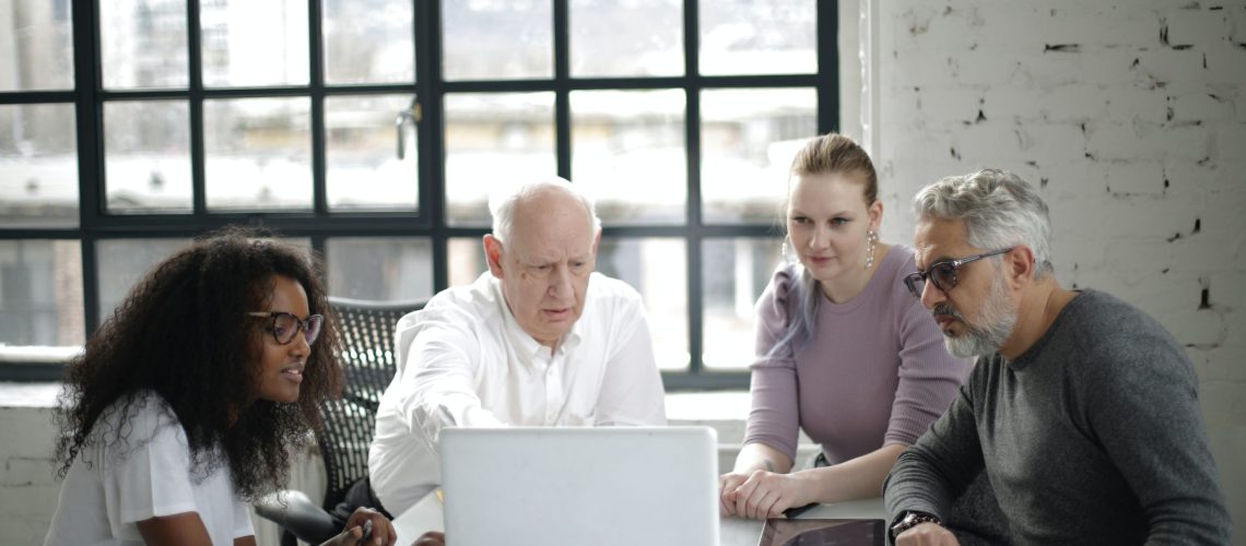 man-in-white-long-sleeved-shirt-presenting-on-a-laptop-3931446