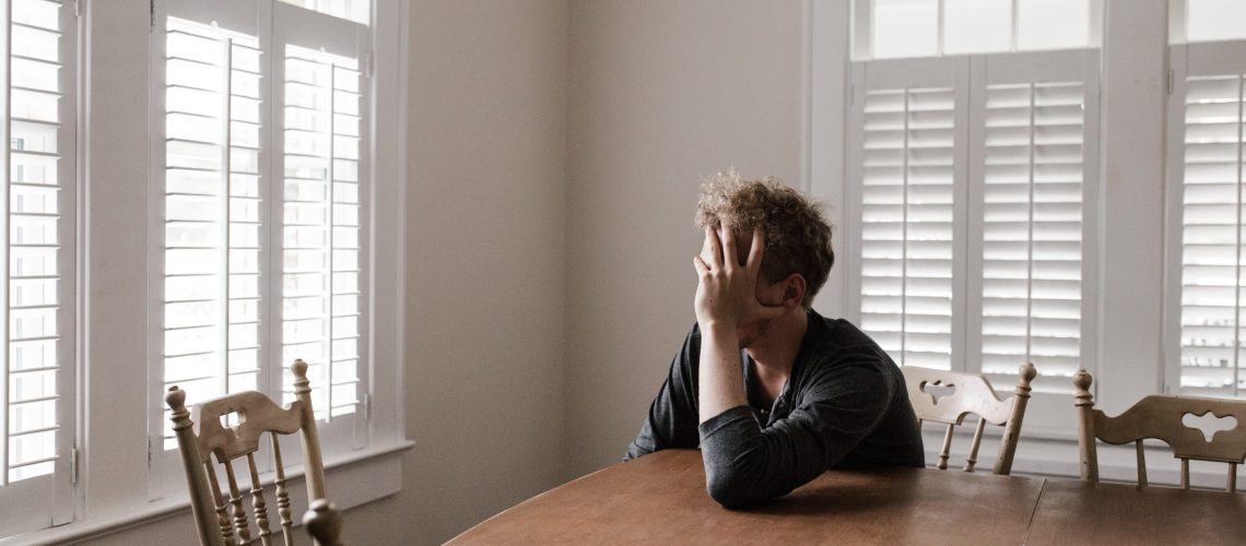 photo-of-man-leaning-on-wooden-table-3132388