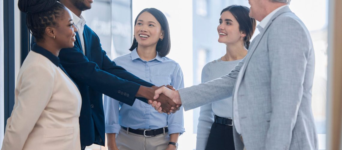 Meeting between different teams and different employees and employers. Different races all working together in a diverse workplace and are happy with a great work culture. Trust handshake