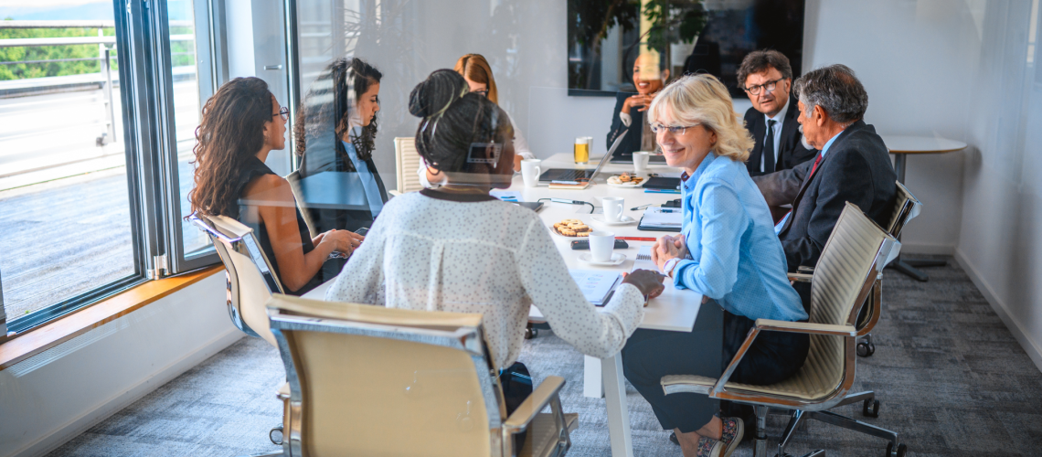 Team of board members from diverse backgrounds all working together in a happy environment to ensure the company is being productive with their employees helping achieve company objectives