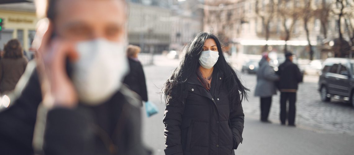 woman-in-black-coat-and-face-standing-on-street-3983428