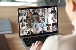 Back view of female employee speak talk on video call with diverse colleagues on online briefing, woman worker have Webcam group conference with coworkers on modern laptop at home virtual meeting remote working